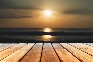 El enfoque selectivo de la mesa de madera vieja con un hermoso fondo de playa foto
