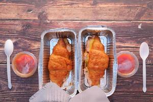 Two croissant sandwiches in takeout containers photo