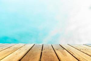 El enfoque selectivo de la mesa de madera vieja con un hermoso fondo de playa para mostrar foto