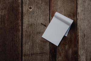 Small white notebook on old grunge wood texture photo