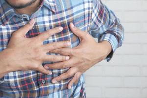 joven agarrando el pecho en el dolor foto