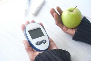 Herramientas de medición para diabéticos con manzana en la mesa foto