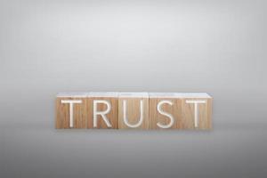 Trust word on wooden board with color background photo