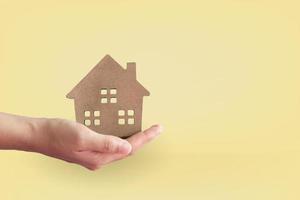 Home or house model on woman hand in pastel color room background photo