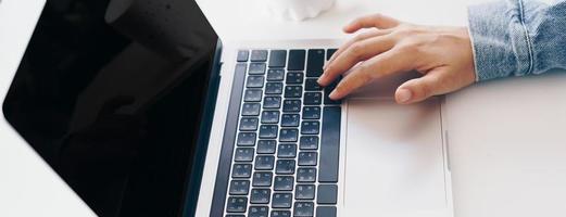 Person using a laptop to work study on desk photo