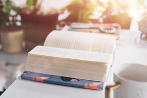 Book on table in workspace area with nature background photo