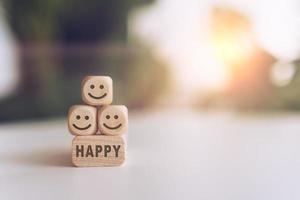 Smiley face and happy word icons on wooden cubes photo