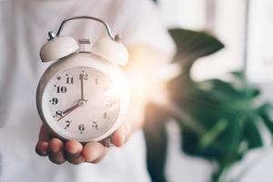 Selective focus of alarm clock with nature bokeh background photo