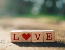 Wooden cubes with heart sign icons with nature sunlight photo