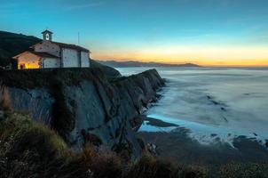 iglesia en acantilado al atardecer foto