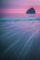 Haystack Rock and tides at sunset on the Oregon Coast photo