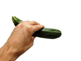 Hand holding a zucchini on a white background