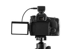 DSLR camera on a tripod isolated on a white background photo
