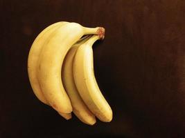 Bananas on a dark wood table background photo