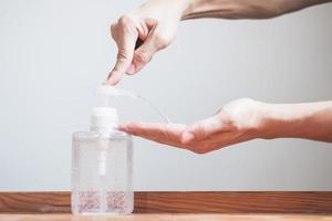 Man hands using hand sanitizer gel dispenser against novel coronavirus or Covid-19, hygiene and healthcare concept photo