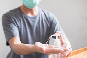 Man hands using hand sanitizer gel dispenser against novel coronavirus or Covid-19, hygiene and healthcare concept photo