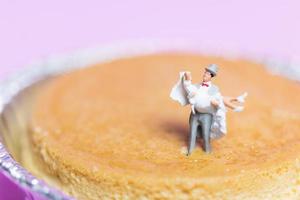 Miniature wedding of a bride and groom couple on a pink background, Valentine's Day concept photo