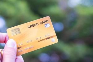 A hand holding a credit card with bokeh background, financial freedom concept photo