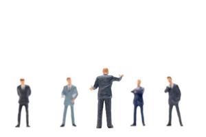 Miniature group of businessmen standing on a white background photo