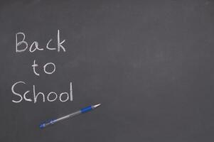 Back to school concept with pen and chalk on blackboard photo