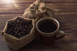 taza de café y granos de café en la mesa foto