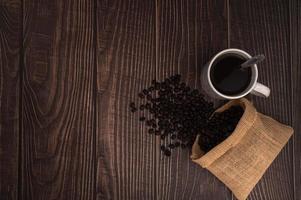 Taza de café con granos de café en una mesa de madera