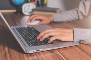 A person typing on a laptop computer photo