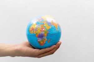 Person holding a small world globe photo