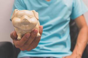 Hand holding a piggy bank photo