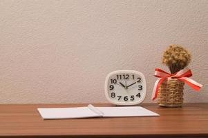 Notebook and clock on the table photo