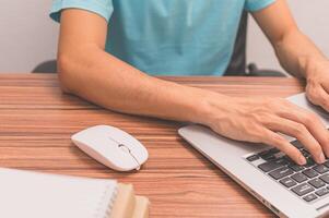 A man typing on a laptop computer photo