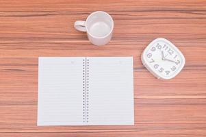 The notebook and the clock on the table photo