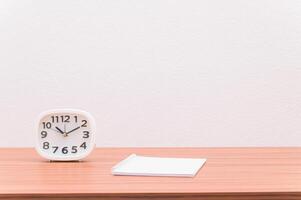 A clock and notepad on a table photo