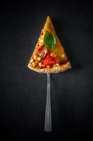 Slice of pizza with tomatoes photo