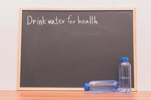 Drink water for health written on blackboard photo