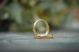 un par de anillos de boda de oro con fondo bokeh foto