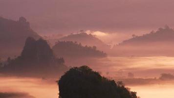 schilderachtig uitzicht op de bergtoppen met mist die bij zonsopgang beweegt video