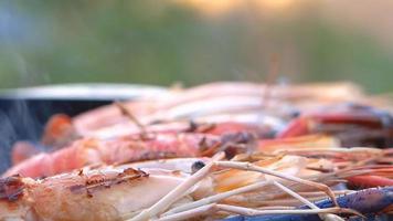 närbild av grillade räkor på en picknick spis som plockas upp video