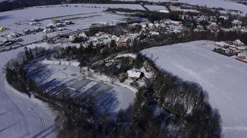 Drohne umkreist gefrorenen See mit Leuten, die an einem sonnigen Wintertag in 4 k Schlittschuh laufen video