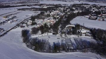 luchtfoto van bevroren meer met mensen die schaatsen op een zonnige winterdag in 4 k video