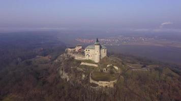 Drone orbitando el antiguo castillo con torre sobre una roca en un soleado día de primavera en 4 k video