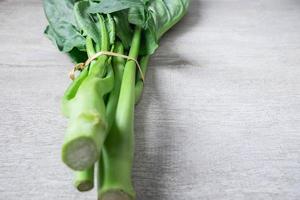 Chinese kale on a white table background photo