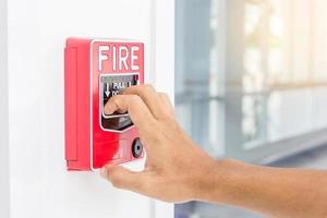 Hand of man pulling fire alarm switch photo