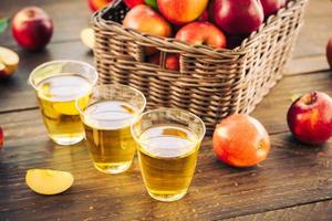 Apple juice in glasses and apples in the basket photo