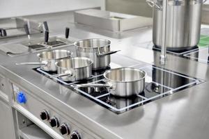 Stainless steel pots built on the stove in the restaurant kitchen photo