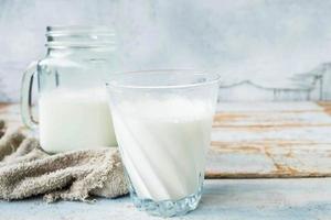 Milk in glasses on a wooden table photo