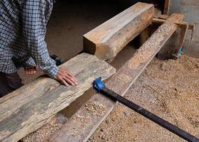 Hombre ajustando una plancha de madera en un taller de carpintería