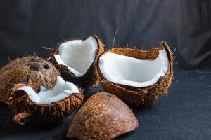 Coconut cut in half on a black table background photo