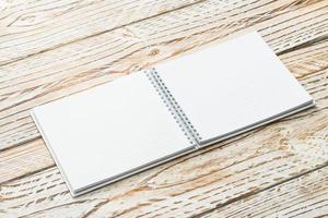 Blank notebook mock up on wooden background photo