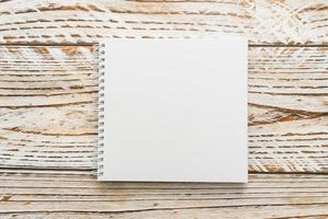 Blank notebook mock up on wooden background photo